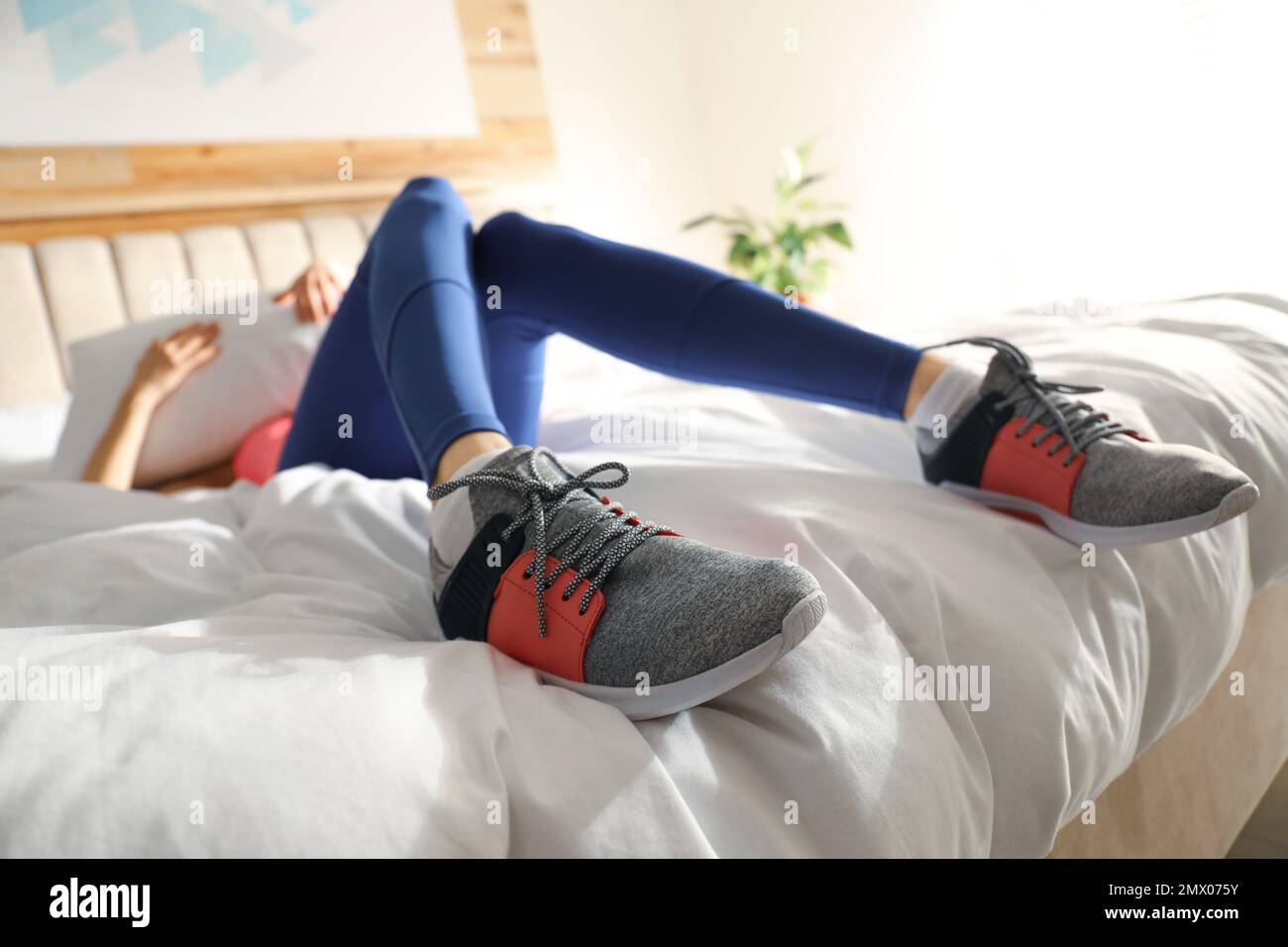 Lazy young woman sleeping on bed instead of morning training, focus on