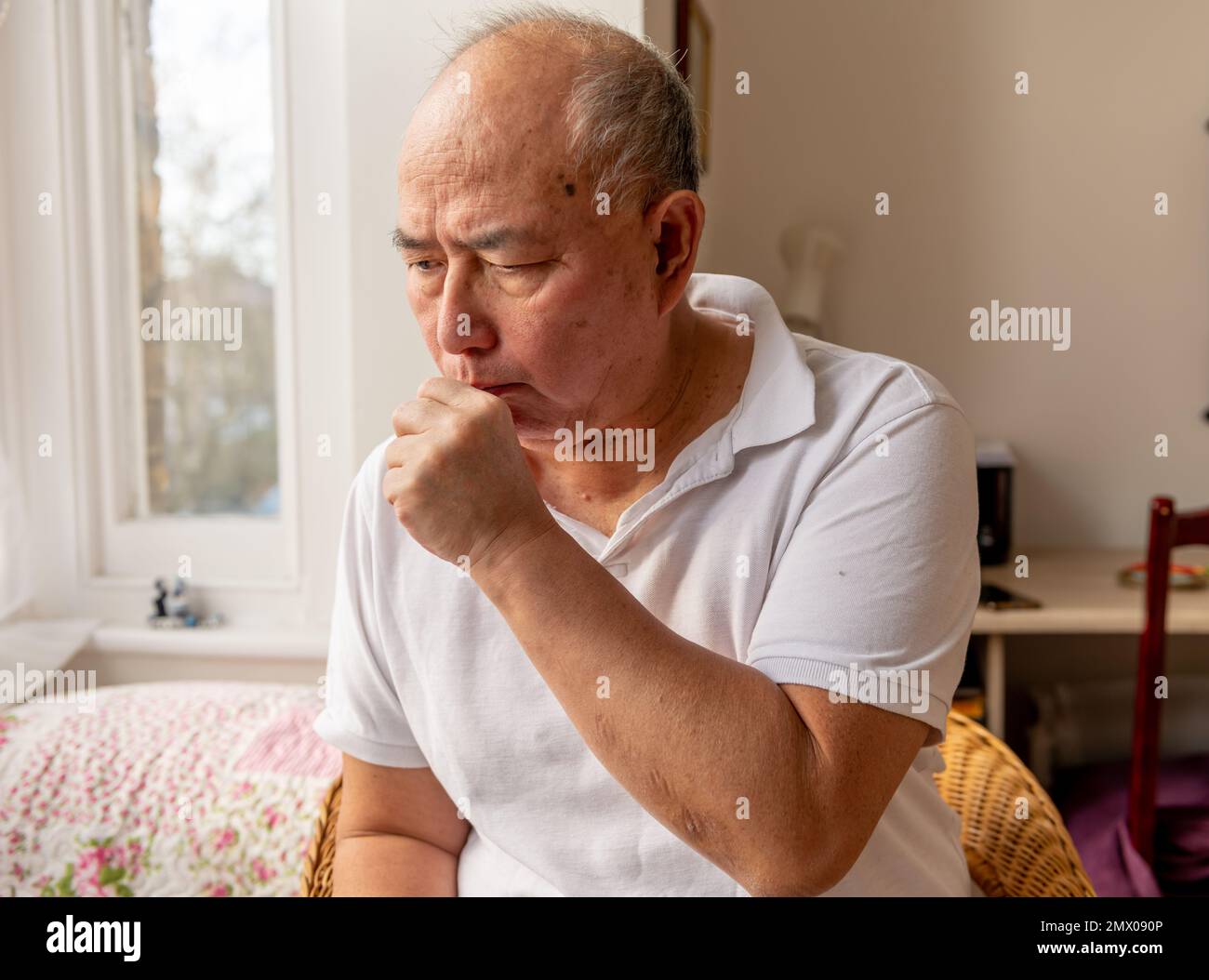 A elderly man coughing. Suffering the symptoms of Winter cold and flu
