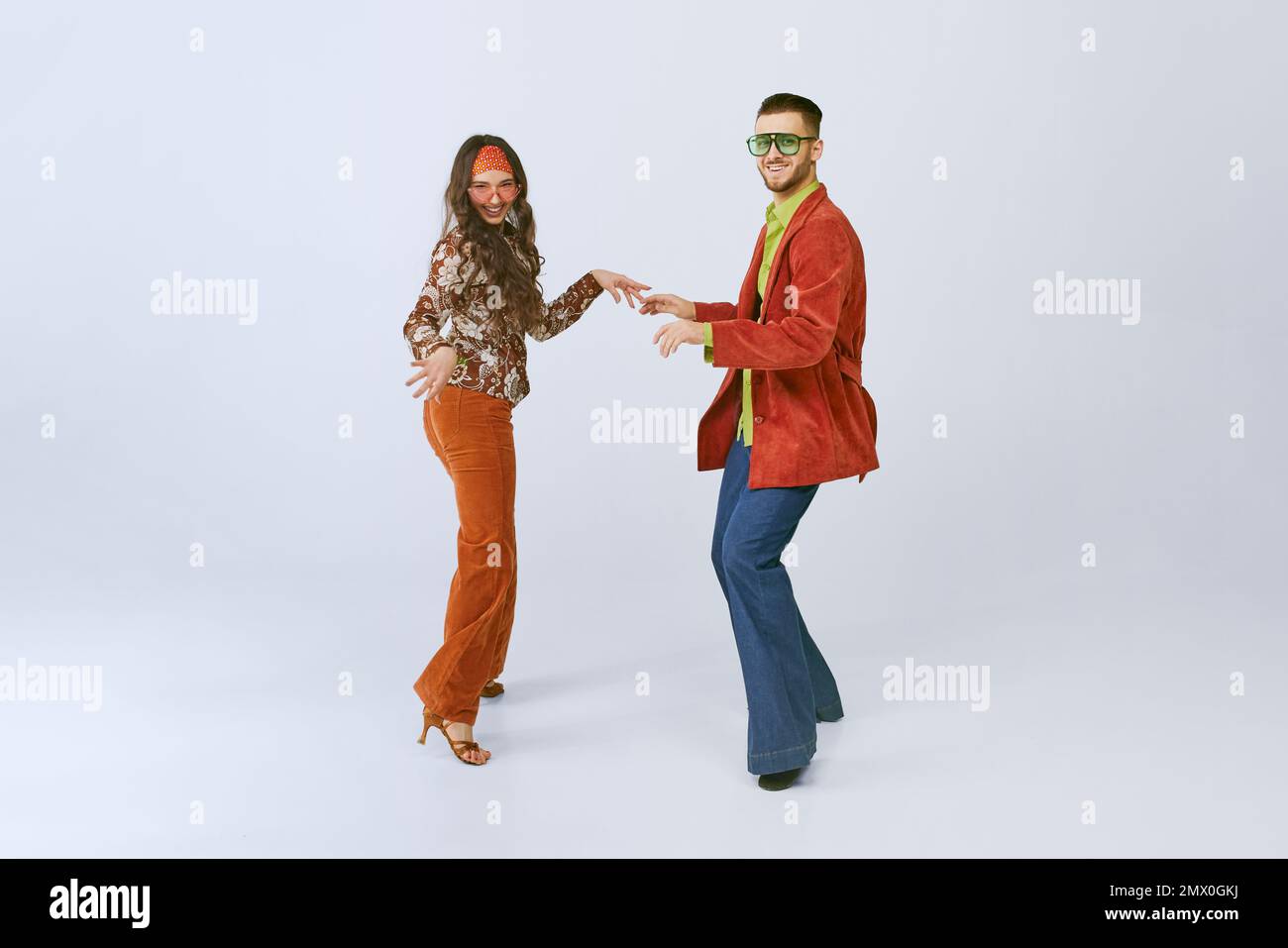Old school party. Stylish young man and woman in colorful retro outfits
