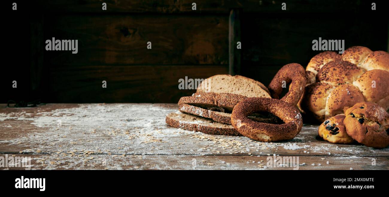 Slices of baked Turkish bread and sweet fresh pastry placed on messy table covered with white flour in light kitchen Stock Photo