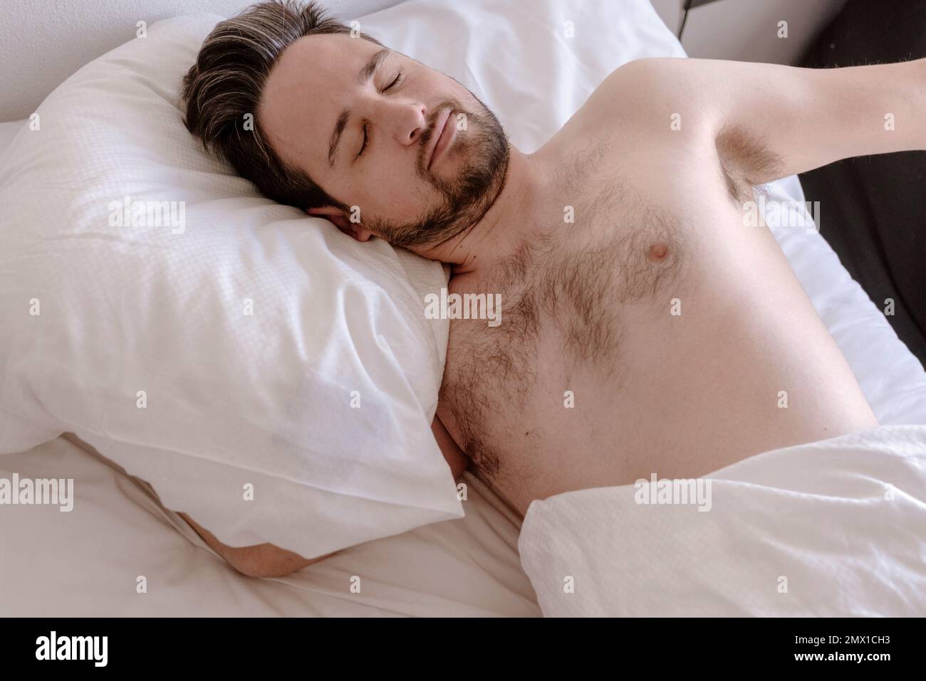 Man sleeping peacefully lying on bed Stock Photo