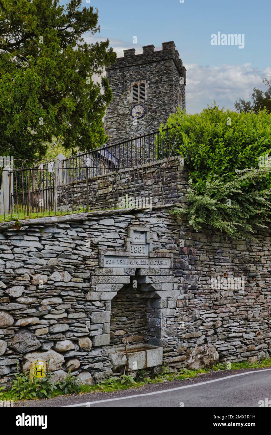 Chapel Stile, Langdale, Lake District, Cumbria, England, UK - Tower of Holy Trinity Church and Queen Victoria memorial water trough in slate wall Stock Photo