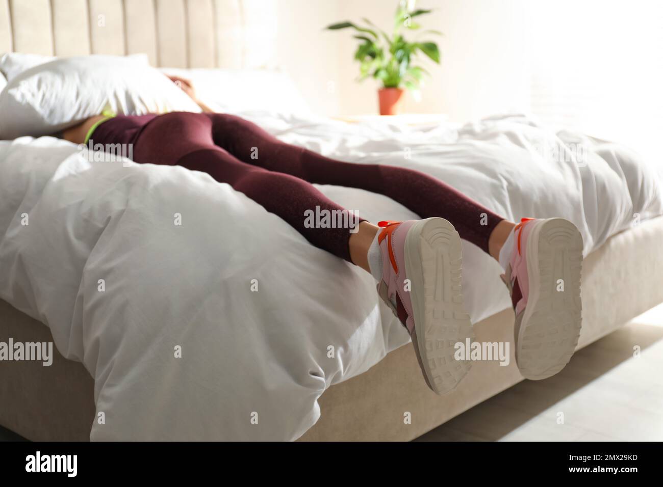 Lazy young woman sleeping on bed instead of morning training, focus on