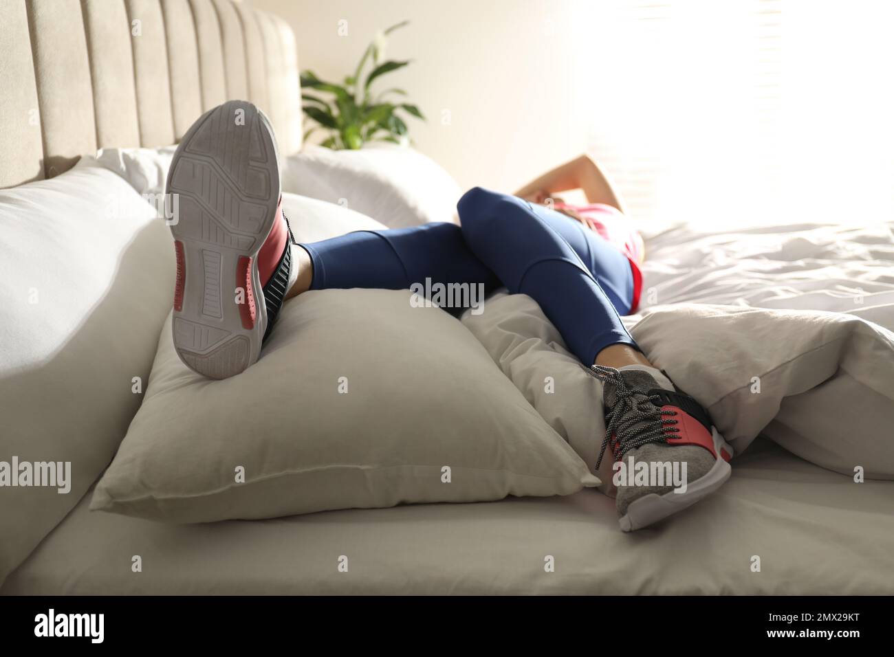 Lazy young woman sleeping on bed instead of morning training, focus on