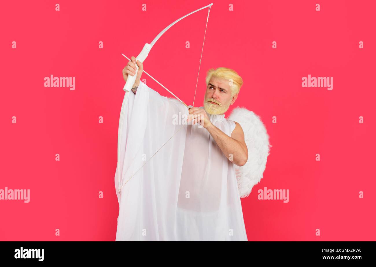Valentines day angel. Handsome cupid aiming up with bow and arrow. God of love. February 14. Stock Photo