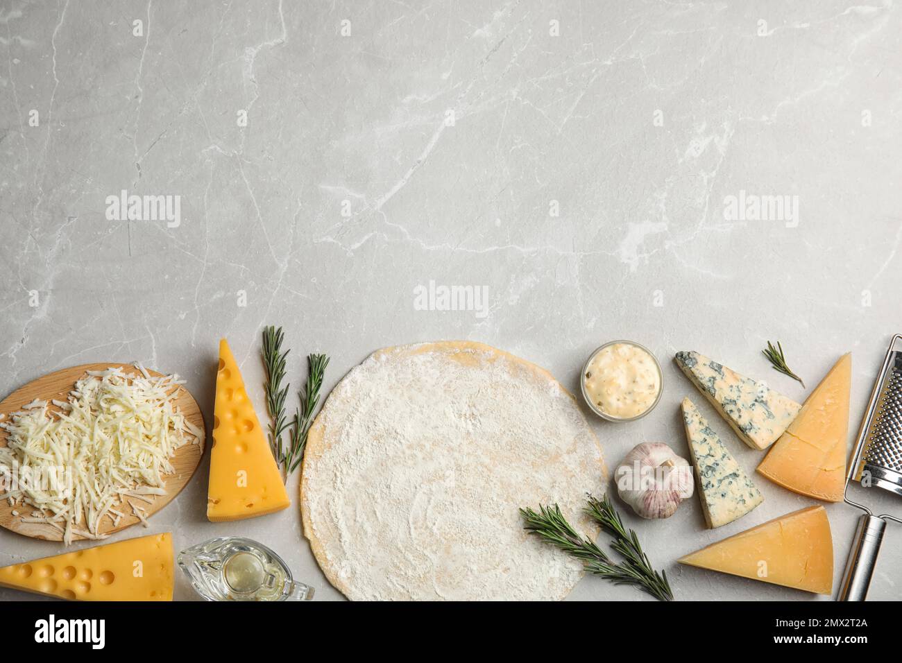 Flat lay composition with dough and fresh ingredients on grey marble ...