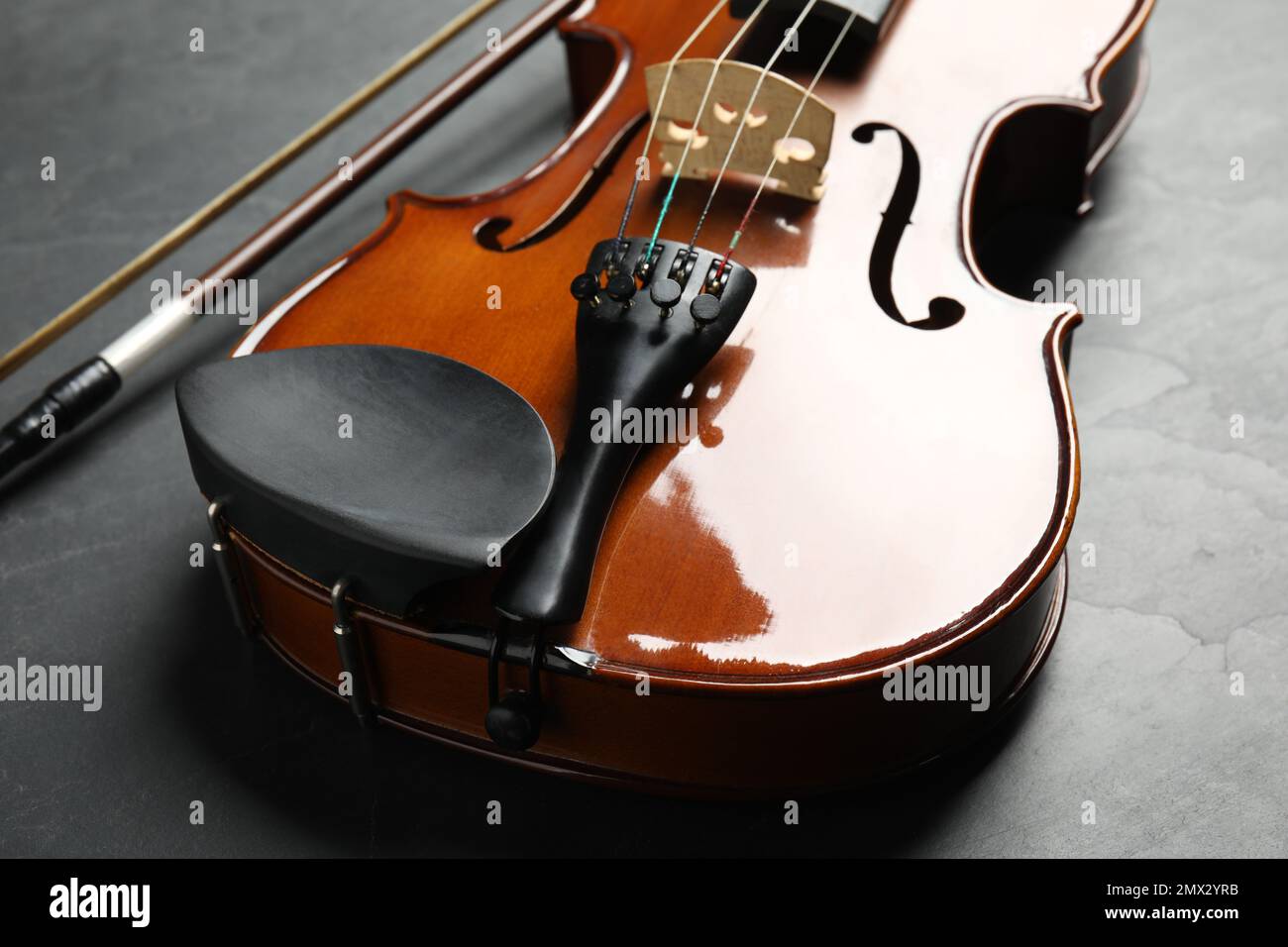 Classic violin and bow on grey stone background, closeup Stock Photo