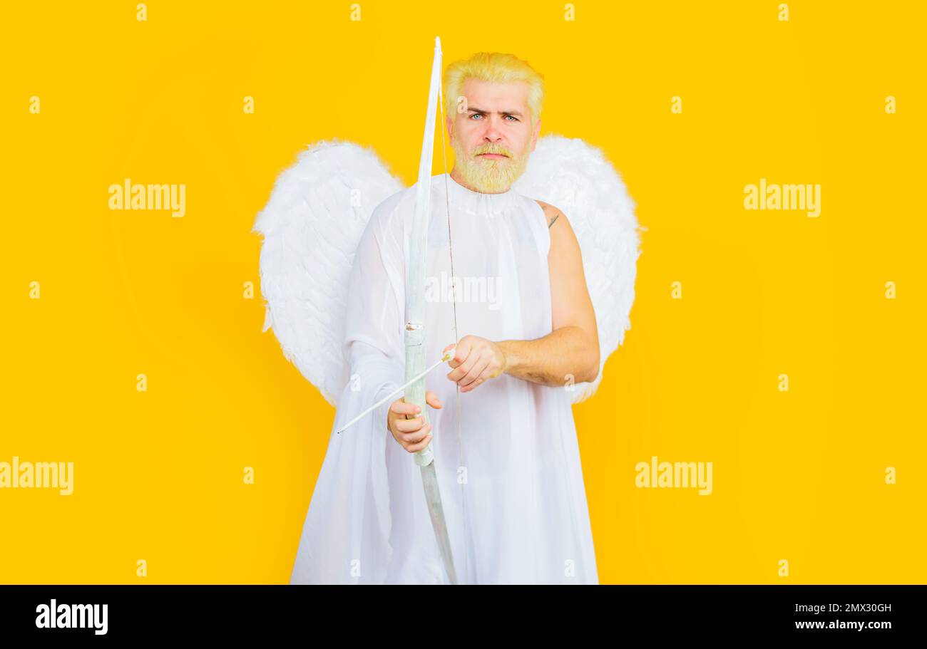 Saint Valentines Day celebration. Male cupid with bow and arrow. Valentine angel in white wings. Stock Photo