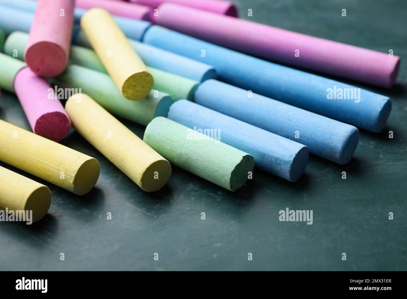 Pieces of color chalk on greenboard, closeup Stock Photo
