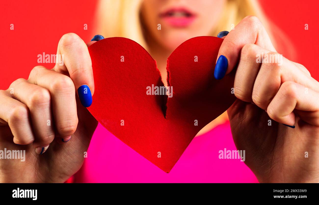 Broken heart. Divorce. Breakup. Woman tearing paper heart. concept. Break of relationships. Closeup. Stock Photo