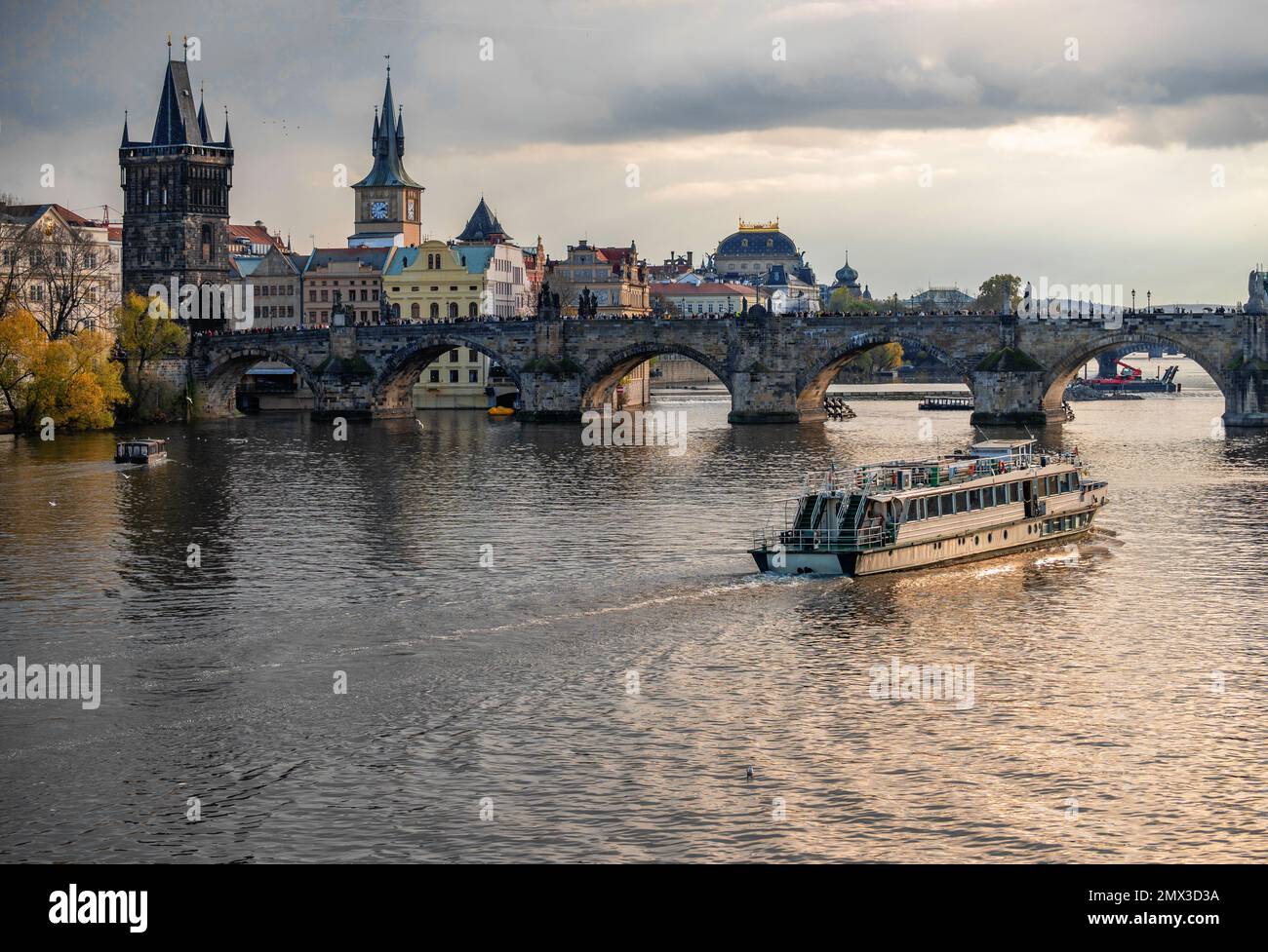 Nice panorama of medieval tower, building, church and Charles bridge, river Vltava with boat. Czech republic, Prague. Nice lighting. Stock Photo