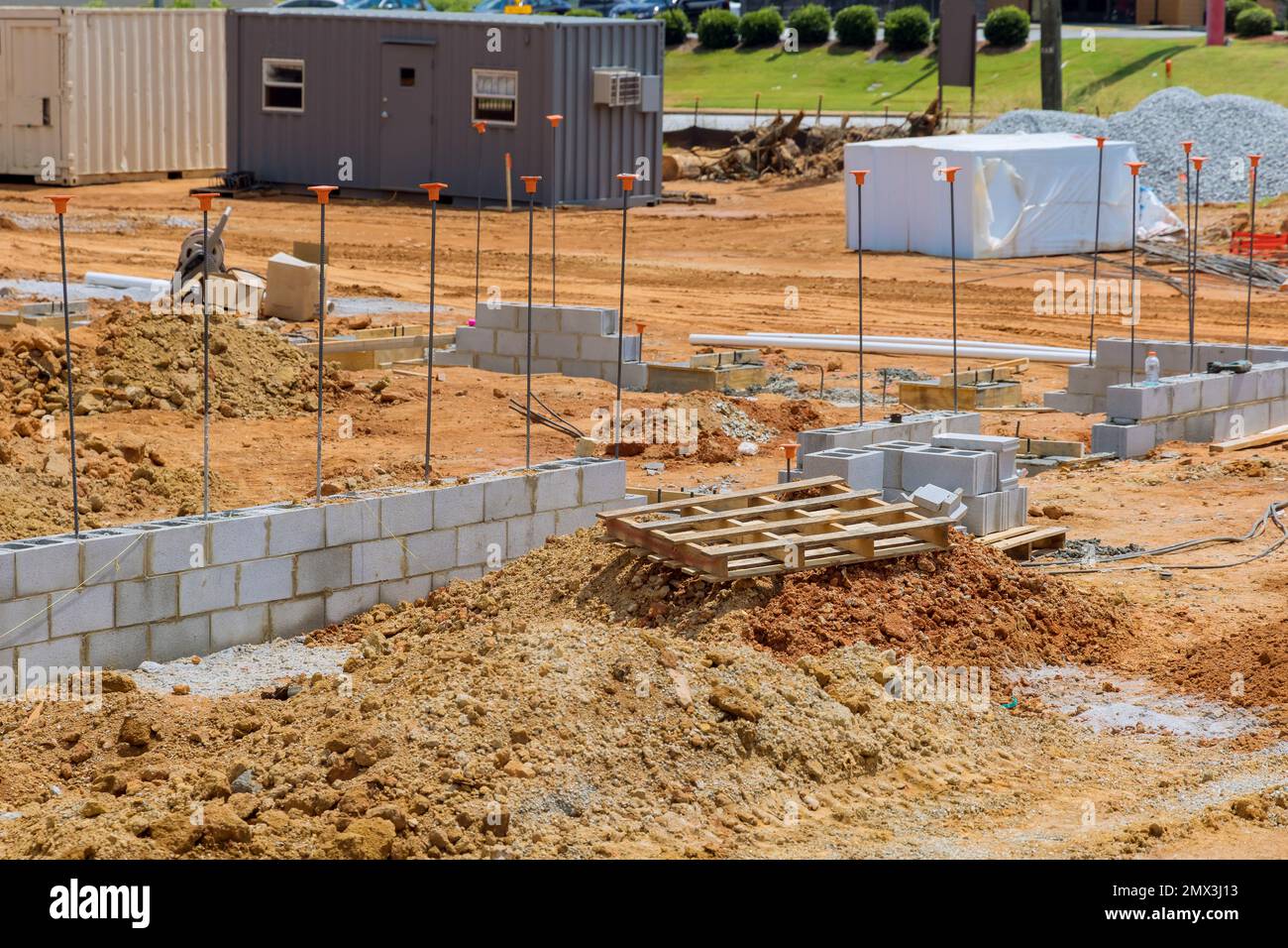 Construction site stacks cement blocks which are ready to be laid on wall of house when work is completed. Stock Photo