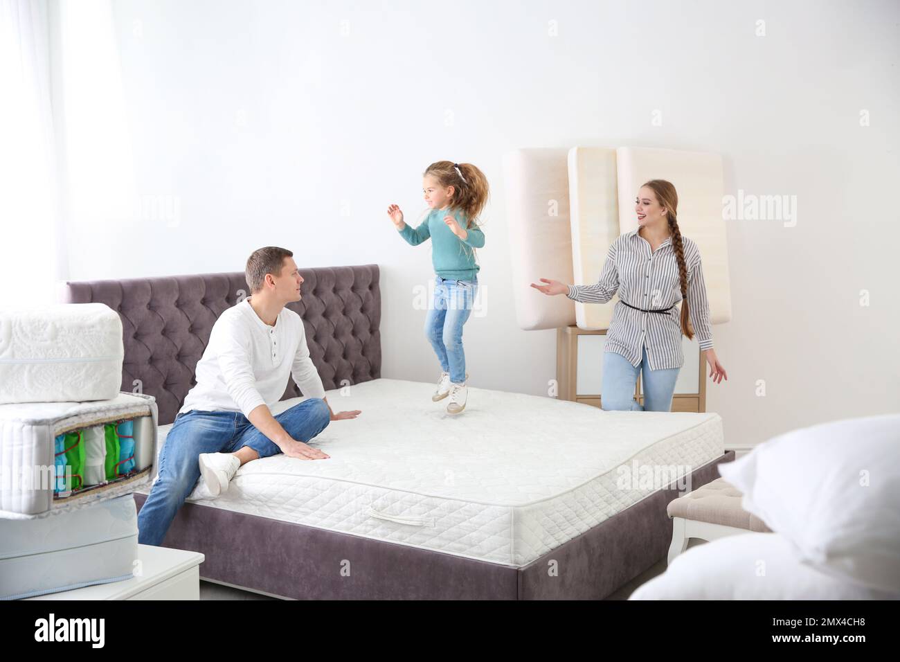 Happy family choosing mattress in furniture store Stock Photo