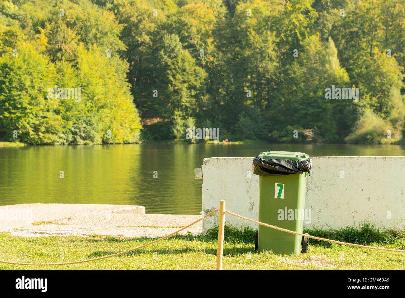 Landscape of green summer lake and forest with recycle bin as recycling environment sustainable dumpster bin concept Stock Photo