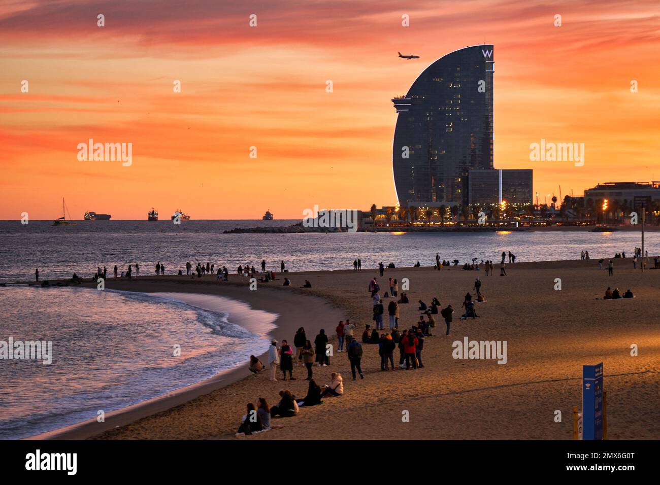 Sunset at Barceloneta Beach, in the background Hotel W, Barcelona, Catalonia, Spain. The sunset on the Barceloneta beach is a unique experience. The Stock Photo