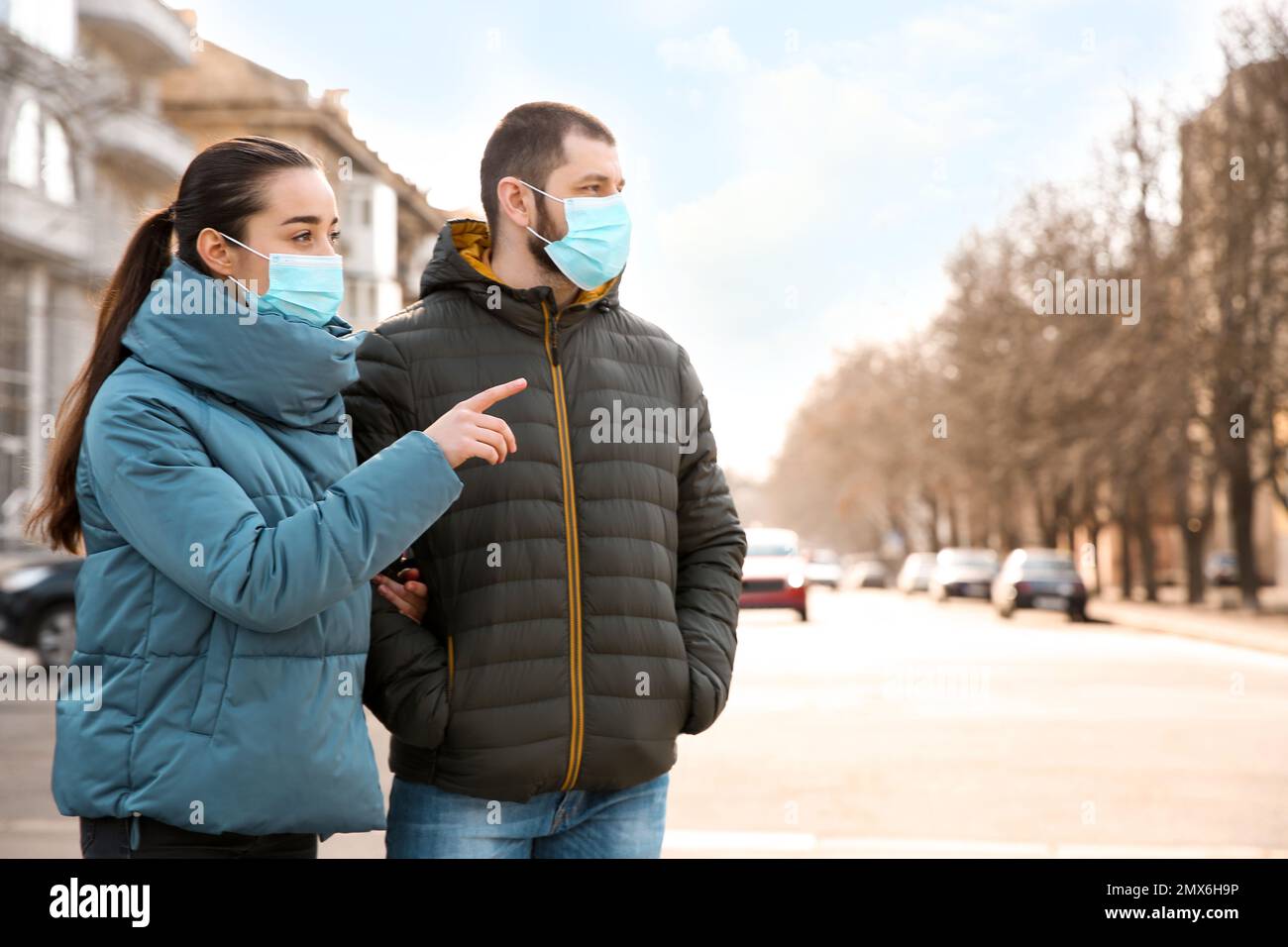 Couple wearing disposable masks outdoors. Dangerous virus Stock Photo