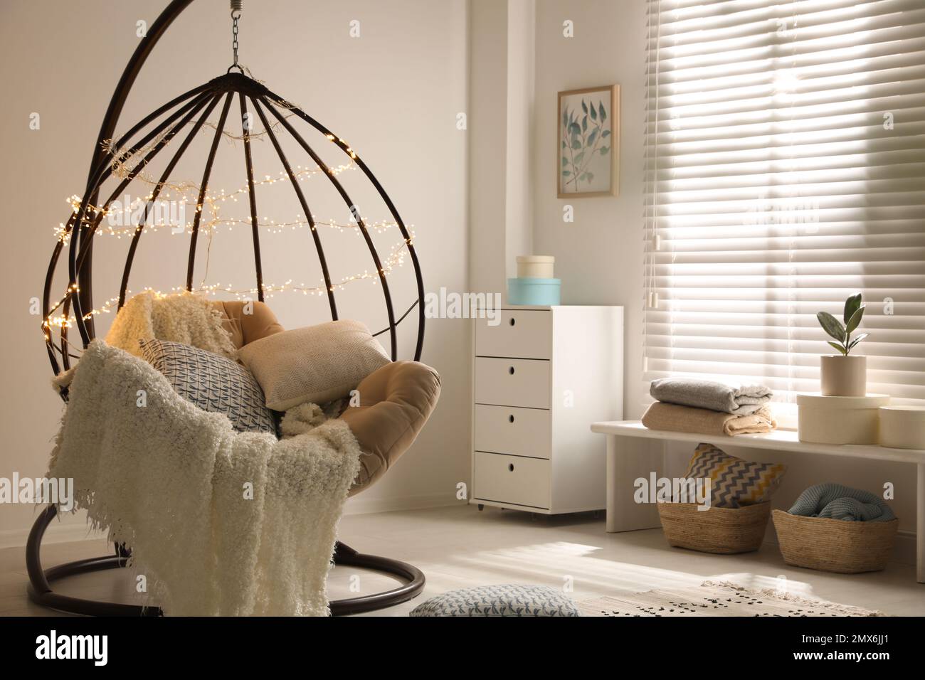 Cozy hanging chair with fairy lights in modern living room. Interior design Stock Photo Alamy