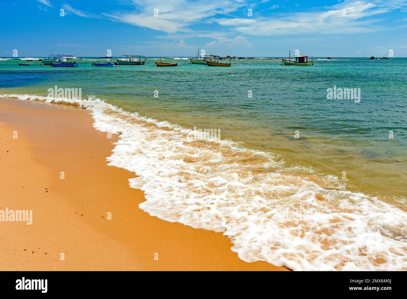 Fishing boats anchored in the waters of the famous Itapua beach in Salvador, Bahia. Stock Photo