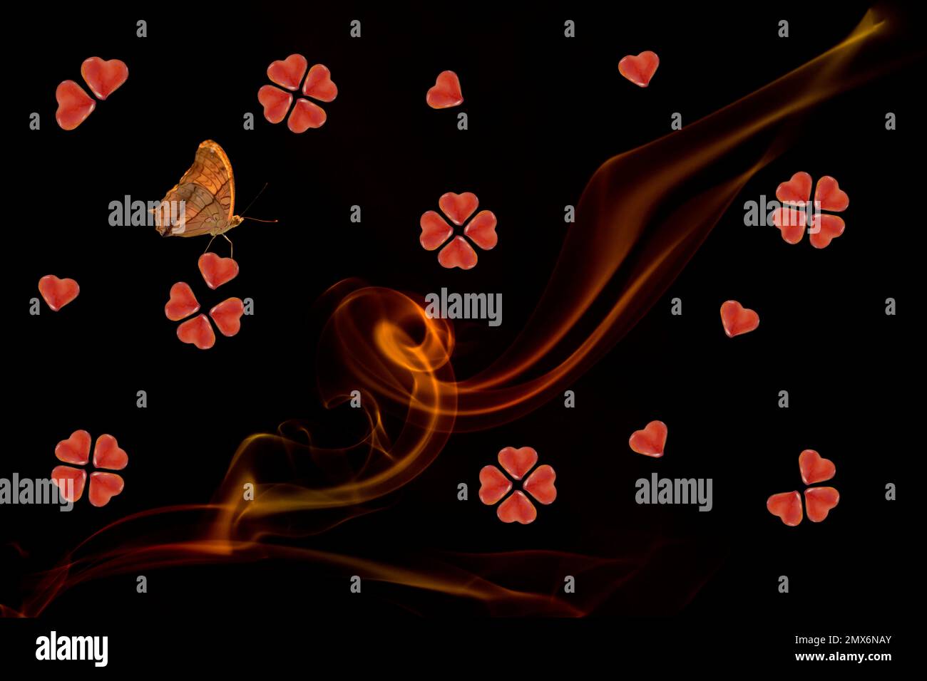 Biscuits in heart shape, line of smoke an a butterfly on a black background Stock Photo