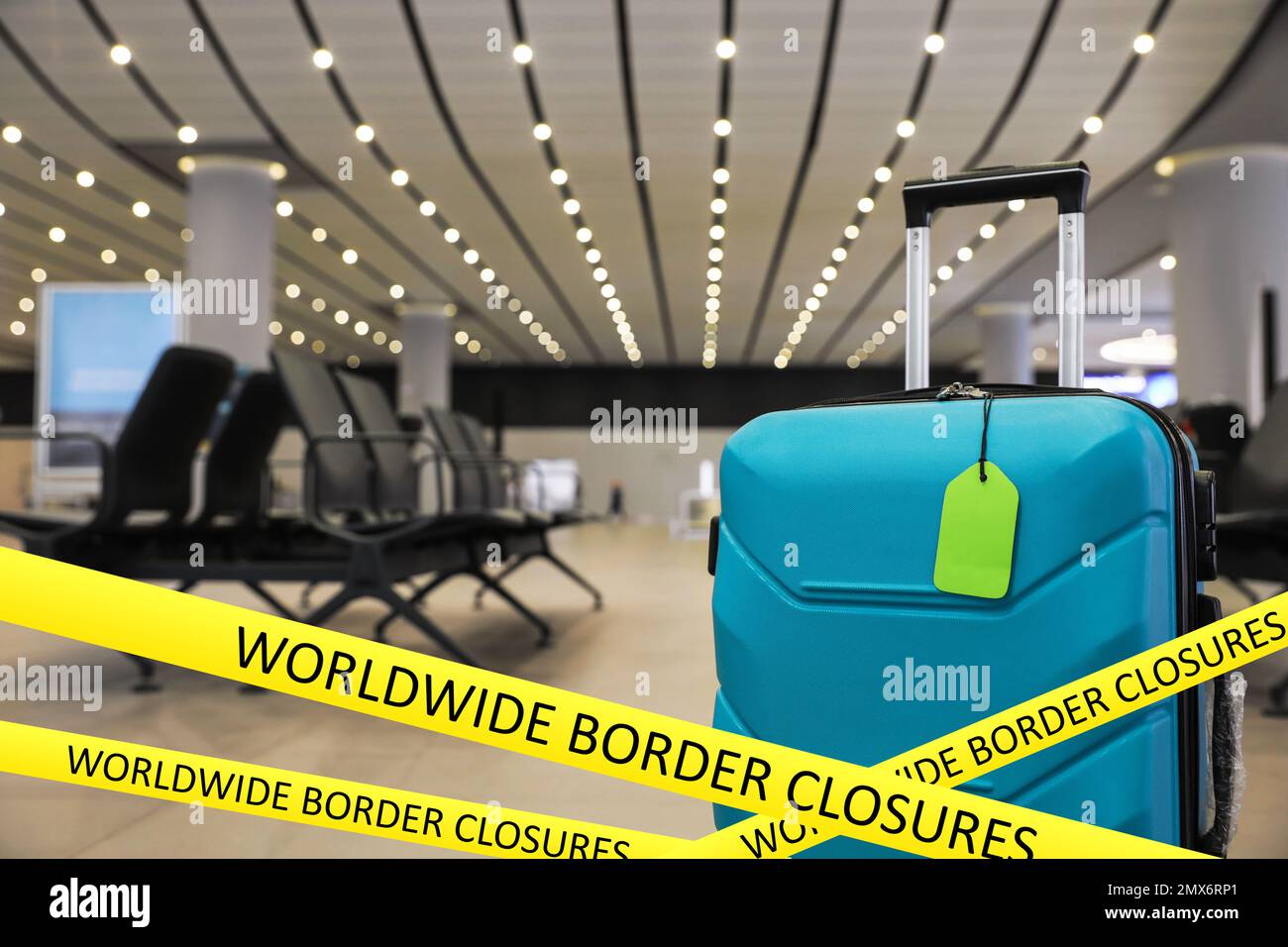 Worldwide border closures through quarantine during coronavirus outbreak. Suitcase in airport and yellow awareness ribbons Stock Photo