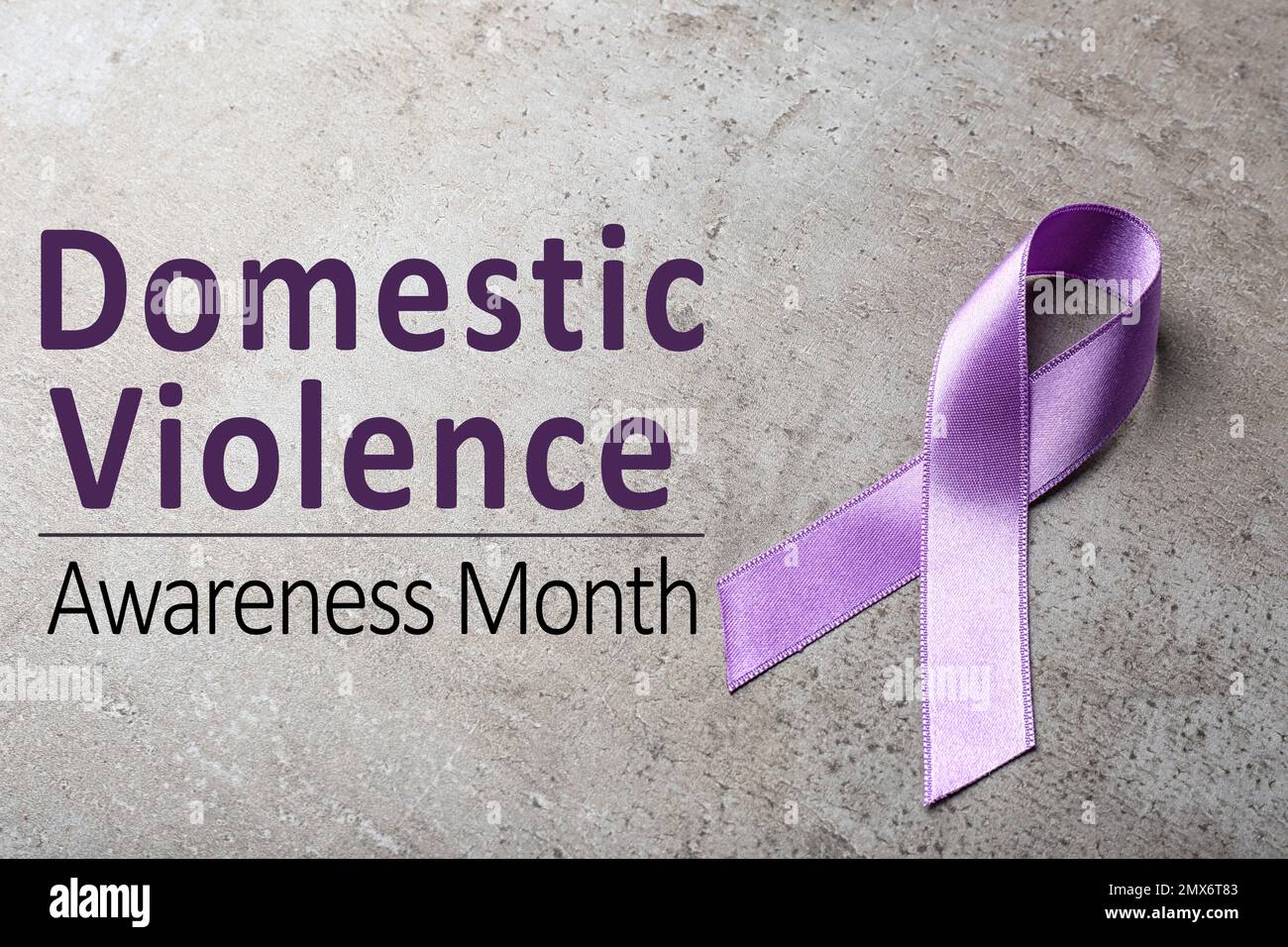 Purple ribbon on grey background. Symbol of Domestic Violence Awareness Stock Photo