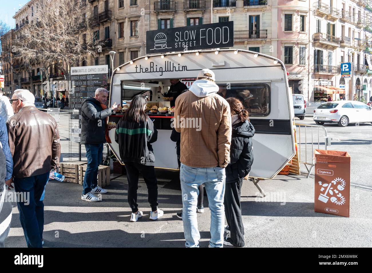 Barcelona, Spain - January 21, 2023: Classic caravan adapted for the sale of fast food on the street with several people waiting Stock Photo
