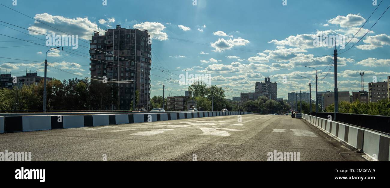 Empty city road against the background of houses and a cloudy summer sky. Photo taken in Chelyabinsk Russia. Stock Photo