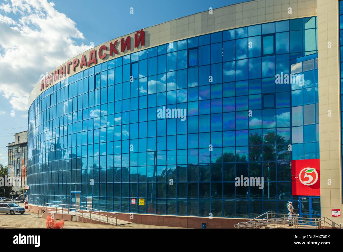 Chelyabinsk, Russia - August 16, 2022. The sky with clouds is reflected in the mirror windows of the building of the Leningradsky shopping center. Stock Photo
