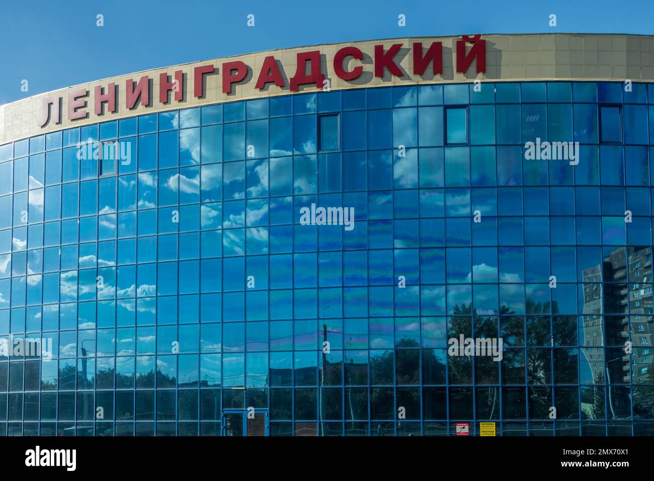 Chelyabinsk, Russia - August 16, 2022. The sky with clouds is reflected in the mirror windows of the building of the Leningradsky shopping center. Stock Photo