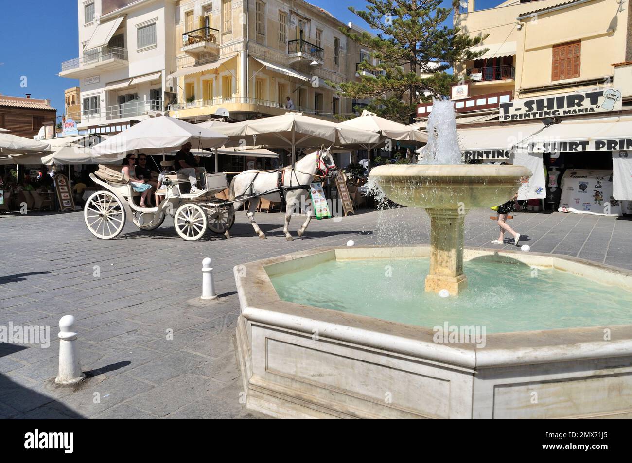Fountain and old-fashioned horse-drawn carriage in the old town of Chania. Stock Photo