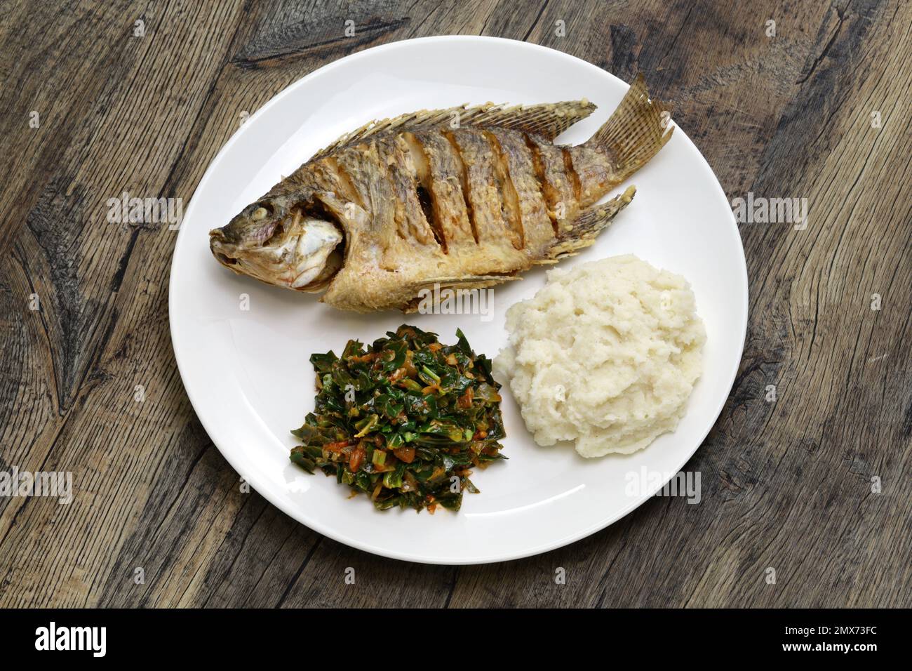 fried fish(Tilapia), ugali(white maize flour mash) and Sukuma Wiki(kale