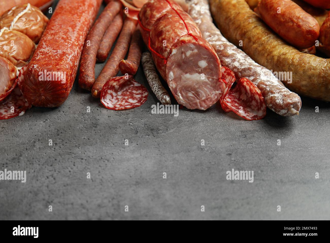 Different types of sausages on grey table. Space for text Stock Photo