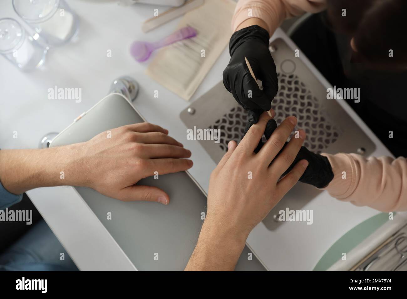 Professional manicurist working with client in beauty salon, closeup ...