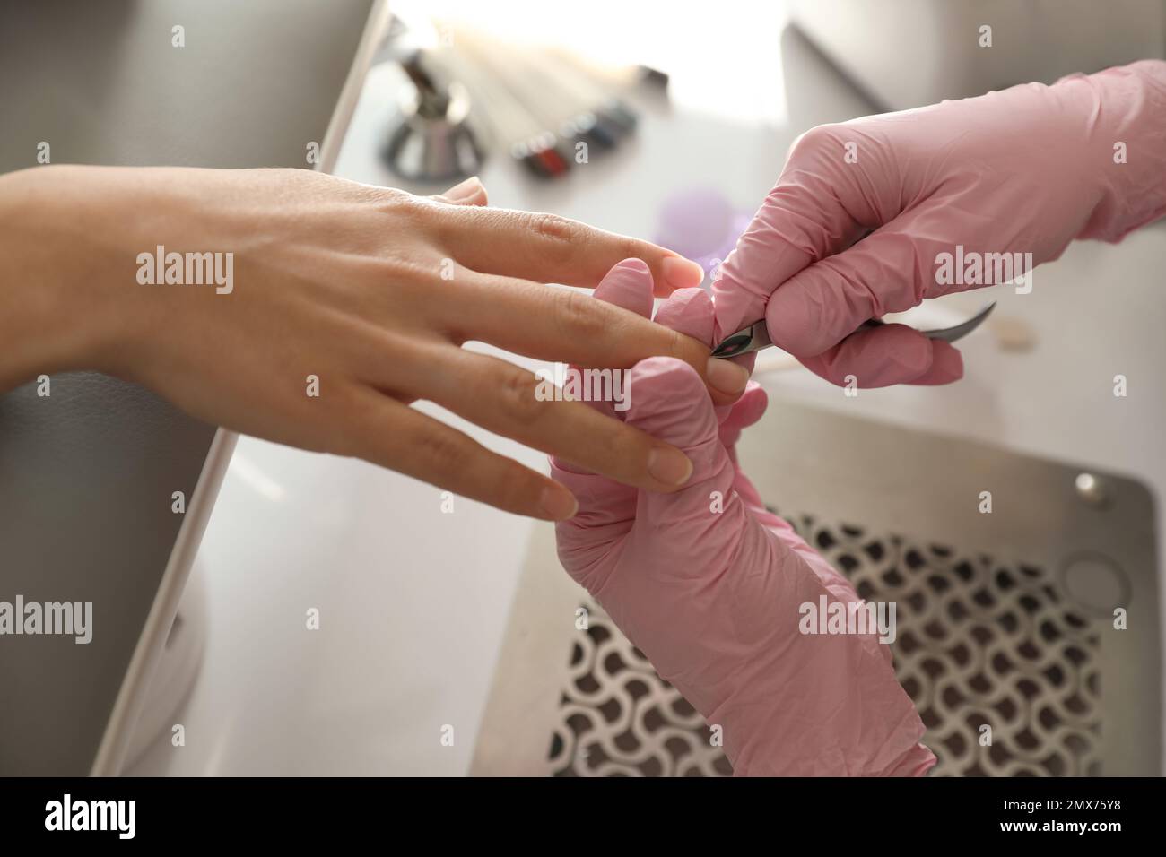Professional manicurist working with client in beauty salon, closeup ...