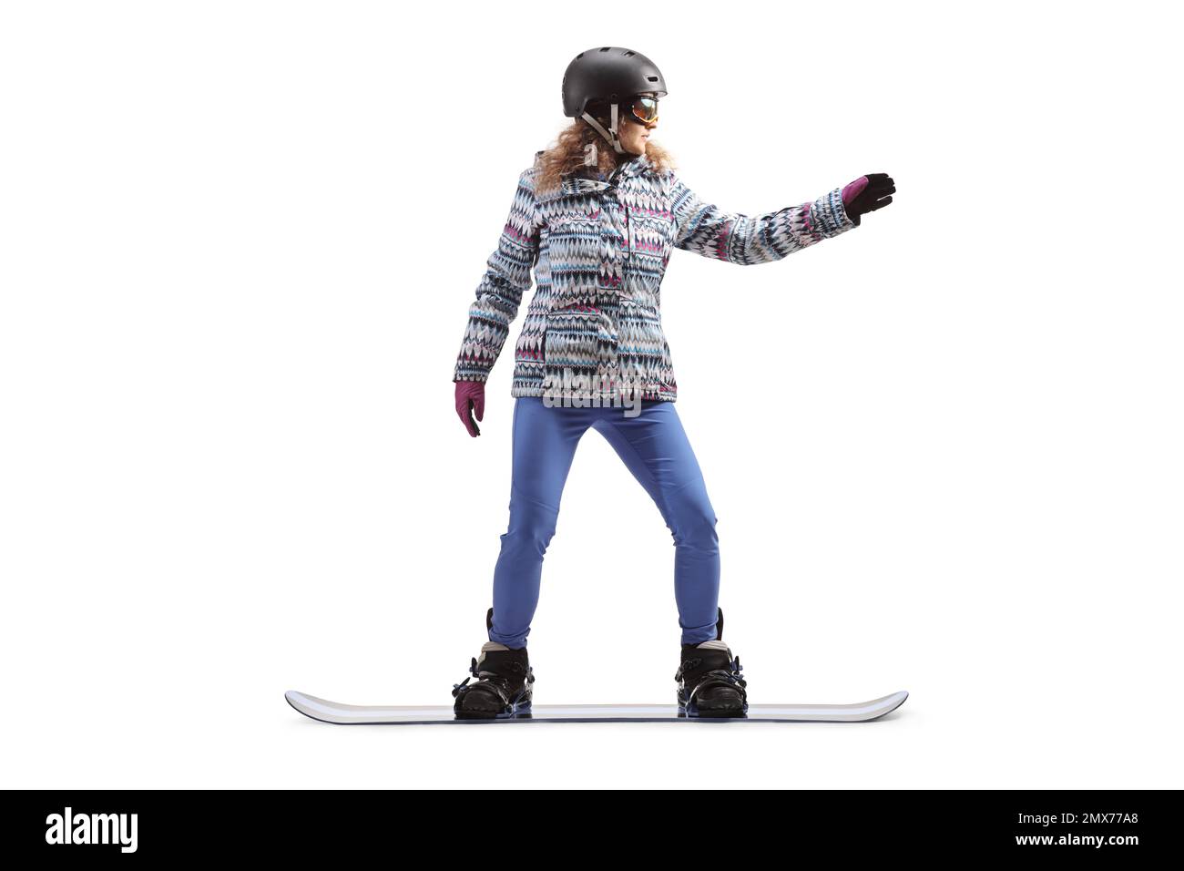 Full length shot of a female with goggles and helmet riding a snowboard isolated on white background Stock Photo