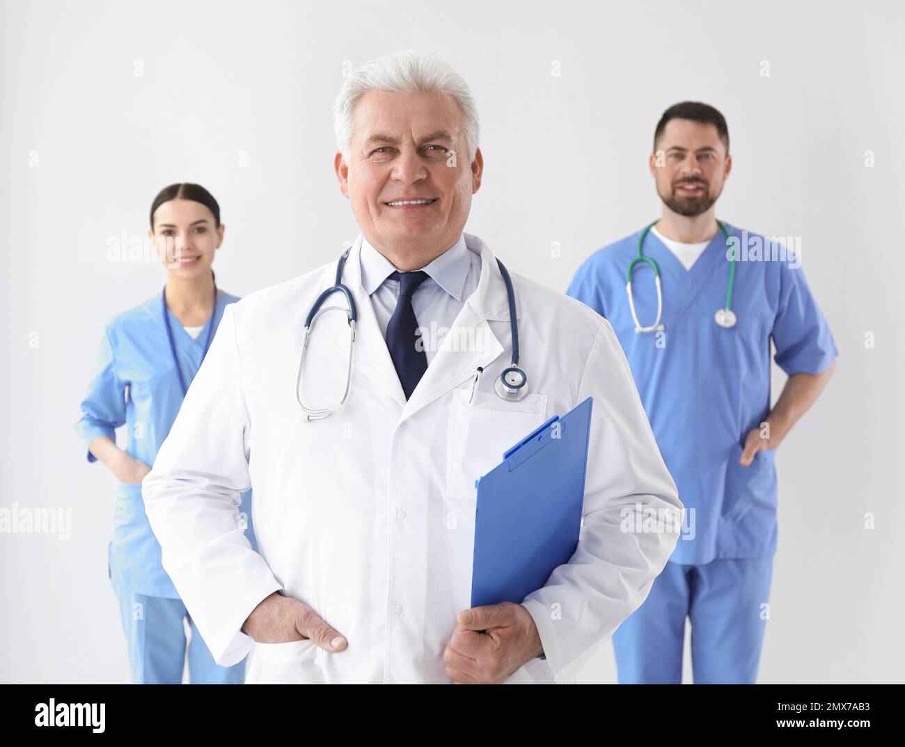Group of doctors against light background. Medical service Stock Photo ...