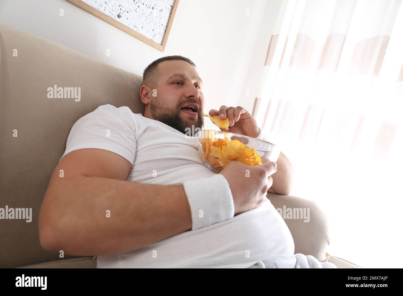 Fat man eating chips hires stock photography and images Alamy