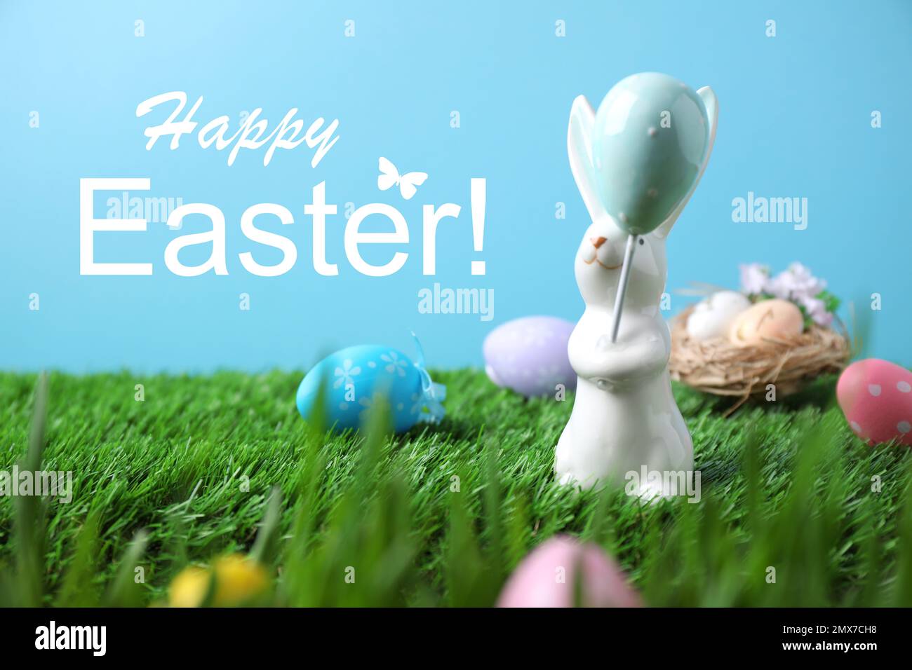 Easter bunny figure and painted eggs on green grass Stock Photo