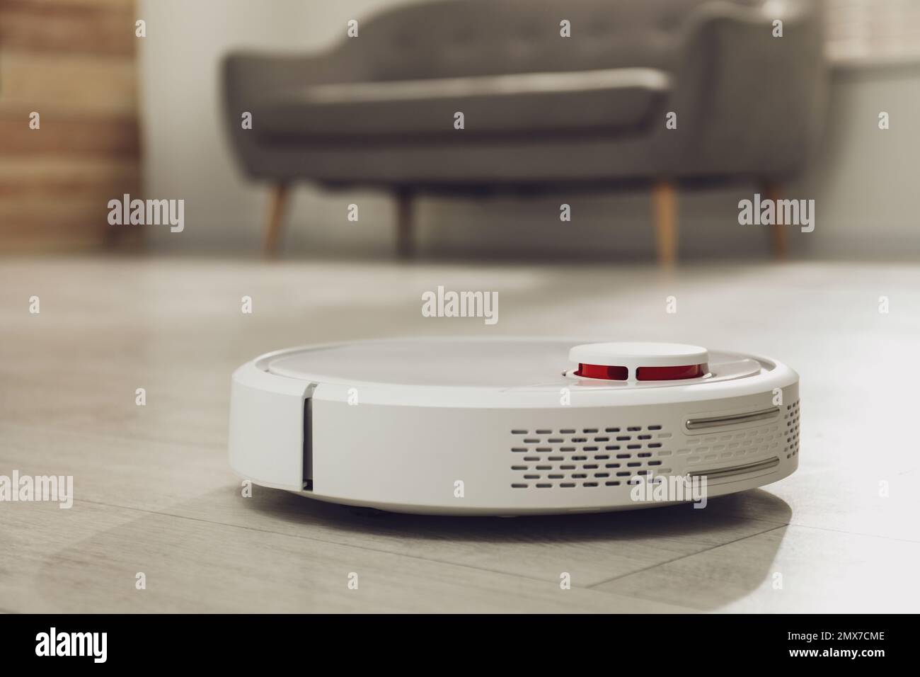 Modern robotic vacuum cleaner on floor in living room Stock Photo - Alamy