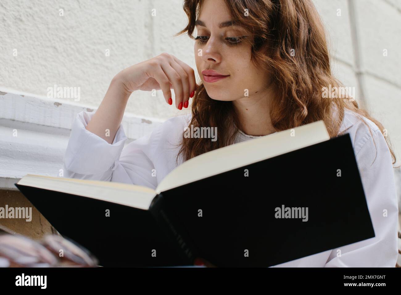 Mockup image magazine book. The girl at the coffee shop table reading book. Stock Photo