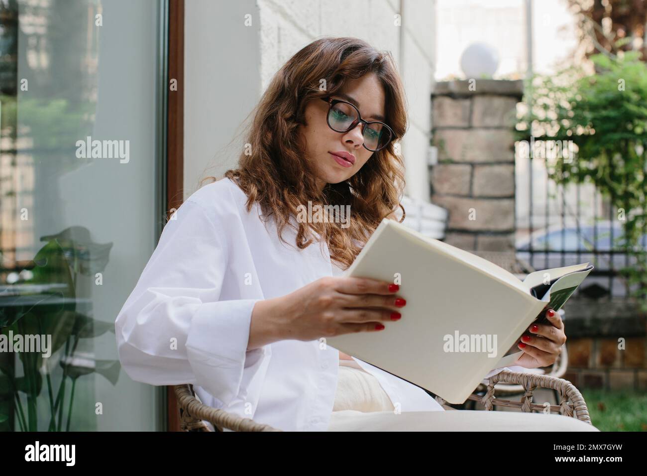 Mockup image magazine book. The girl at the coffee shop table reading magazine. Stock Photo