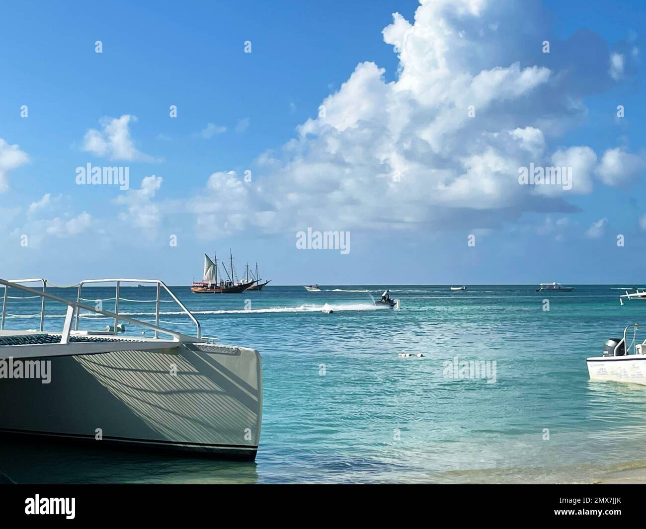 Sailboats and personal watercraft on the Caribbean sea, off the coast of Aruba. Stock Photo