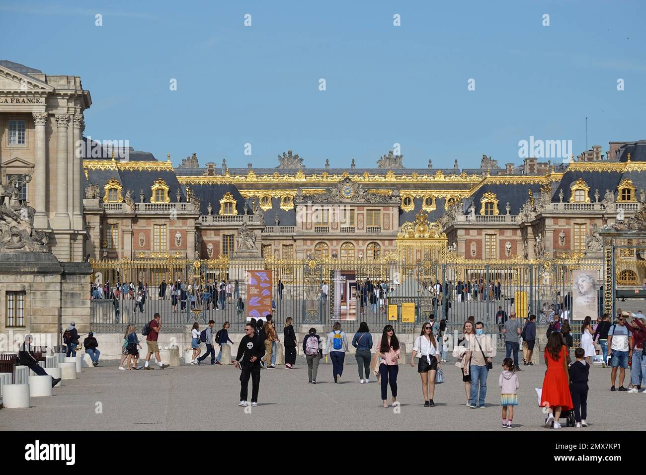 France, Versailles, Panorama picture of the famous Palace of Versailles near the golden royal gate where visitors are queuing at the entrance in the c Stock Photo