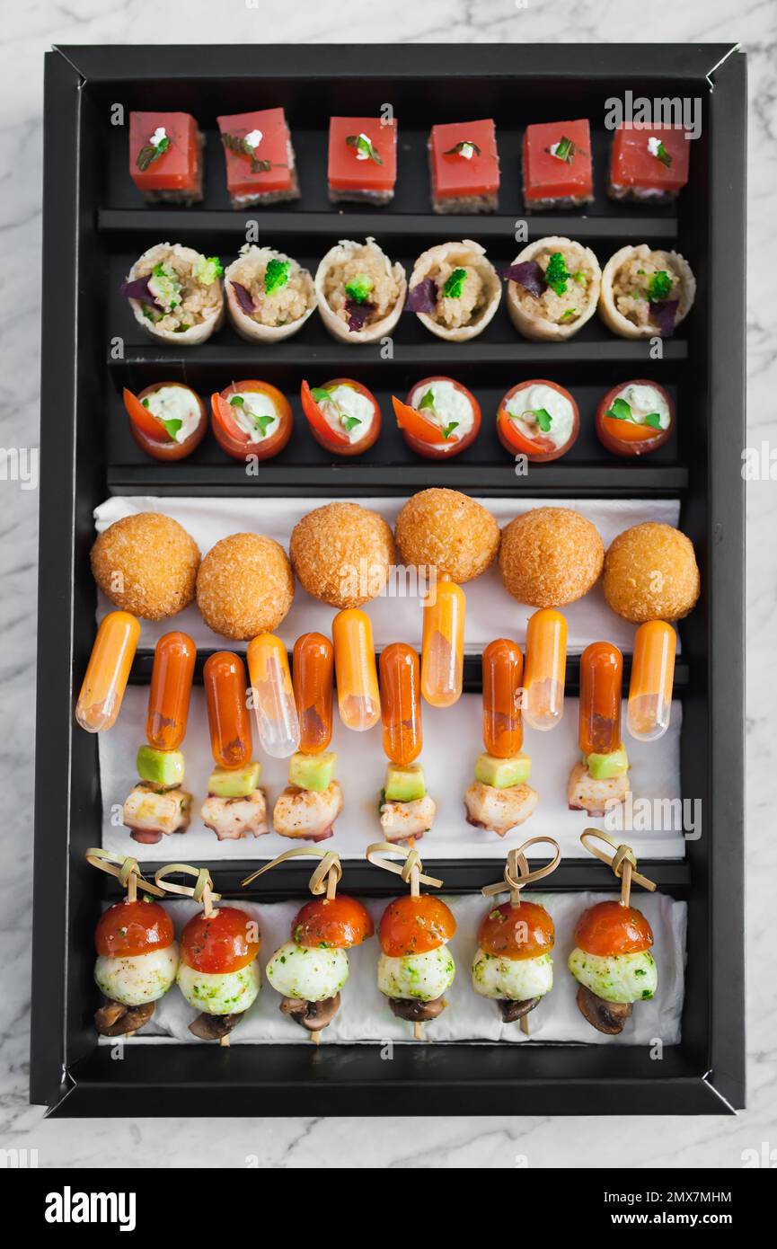 Top view of gourmet hors d'oeuvres in a rectangular box. Mixed