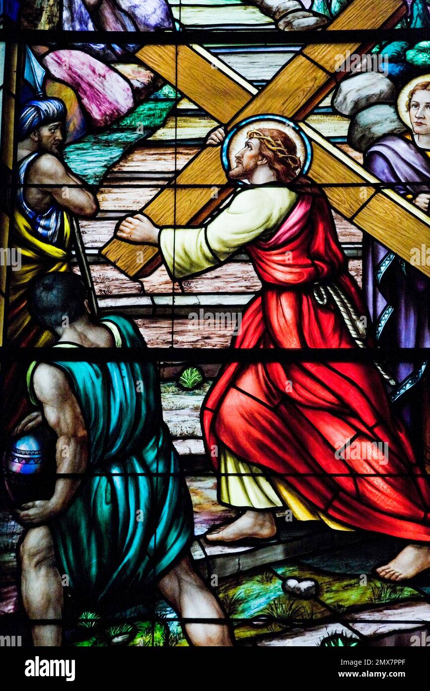 Stained glass window with religious scene showing Jesus carrying the
