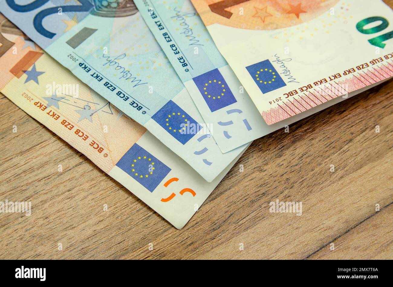 different euro banknotes on wooden table Stock Photo