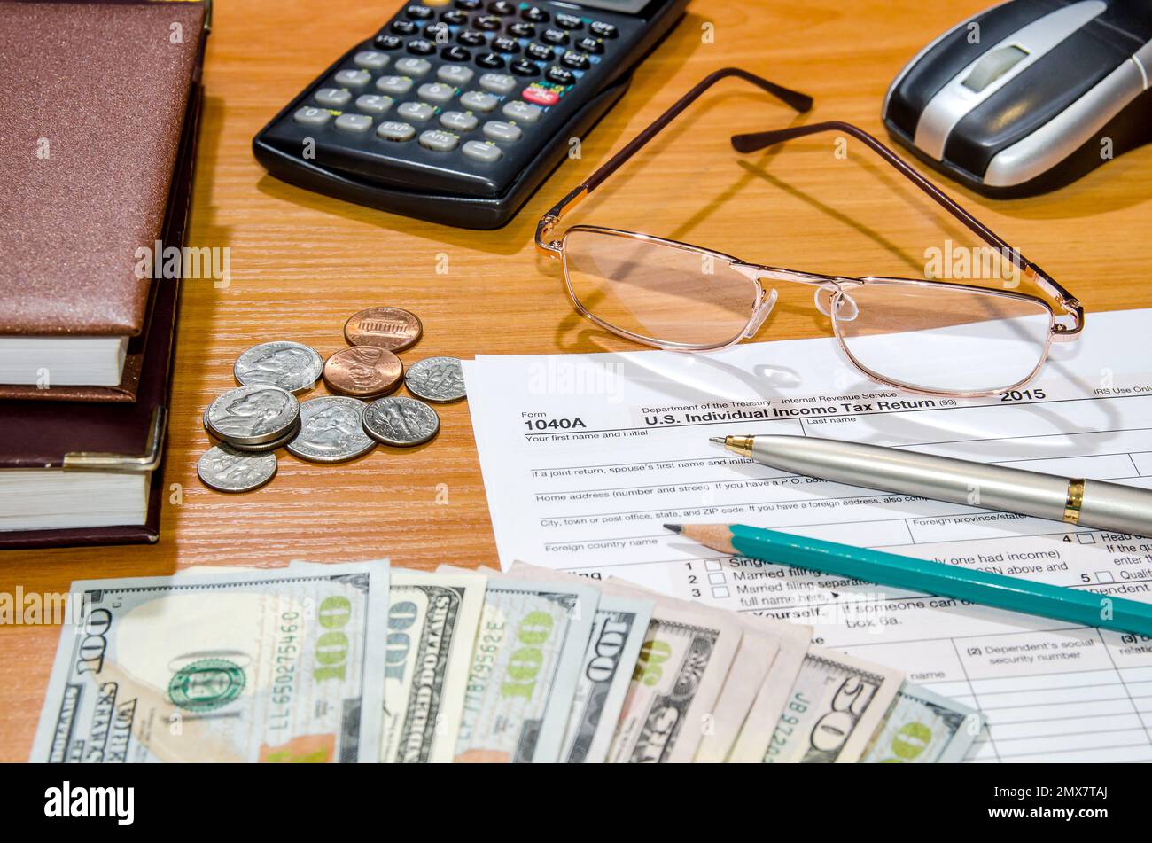 1040 Tax form for 2016 with pen, glasses, dollars and calculator Stock Photo