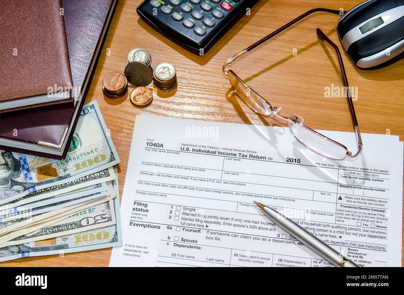 1040 Tax form for 2016 with pen, glasses, dollars and calculator Stock Photo