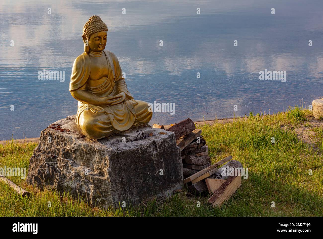 A meditation buddha sits near the waters of a bay on Ontario's Manitoulin Island. Stock Photo