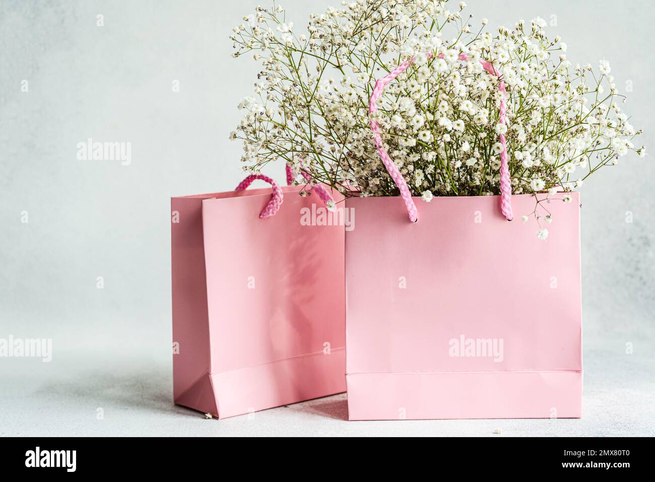 Pink paper bags and white Gypsophila flowers as a shopping concept Stock Photo